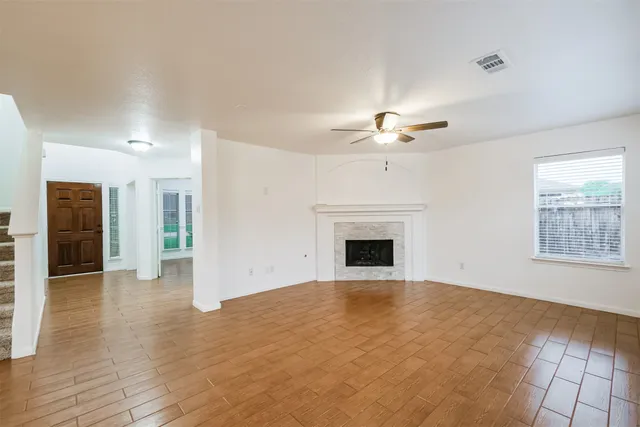 an empty room with fan and windows