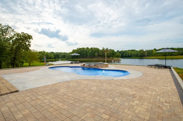 a view of swimming pool with lounge chair in front of house