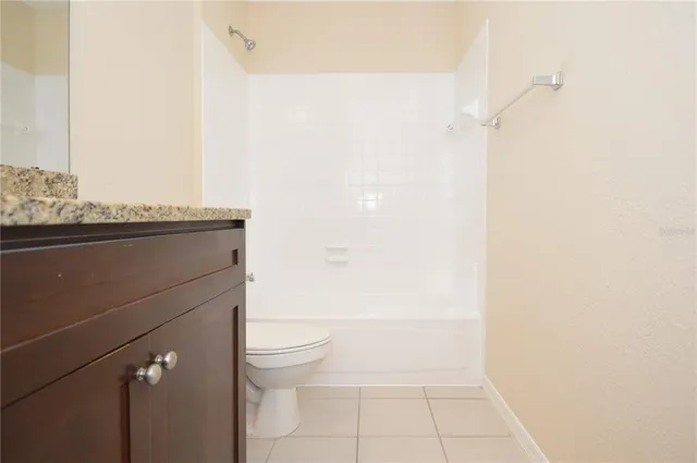 an empty room with a fan and a chandelier fan