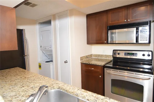 a kitchen with granite countertop a refrigerator and a sink