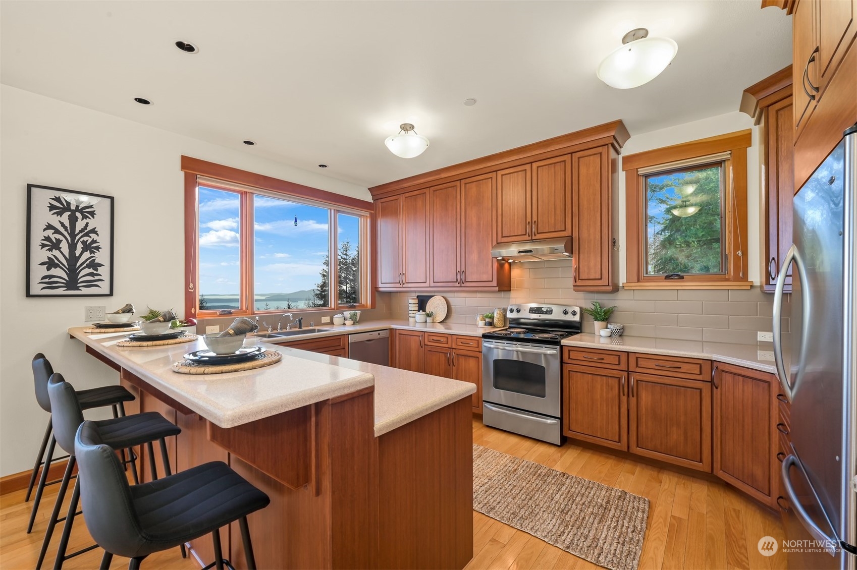 887 Chuckanut Ridge Drive Bow, WA 98232 - Photo 12 of 35 a kitchen with a stove a sink dishwasher and a refrigerator with wooden floor