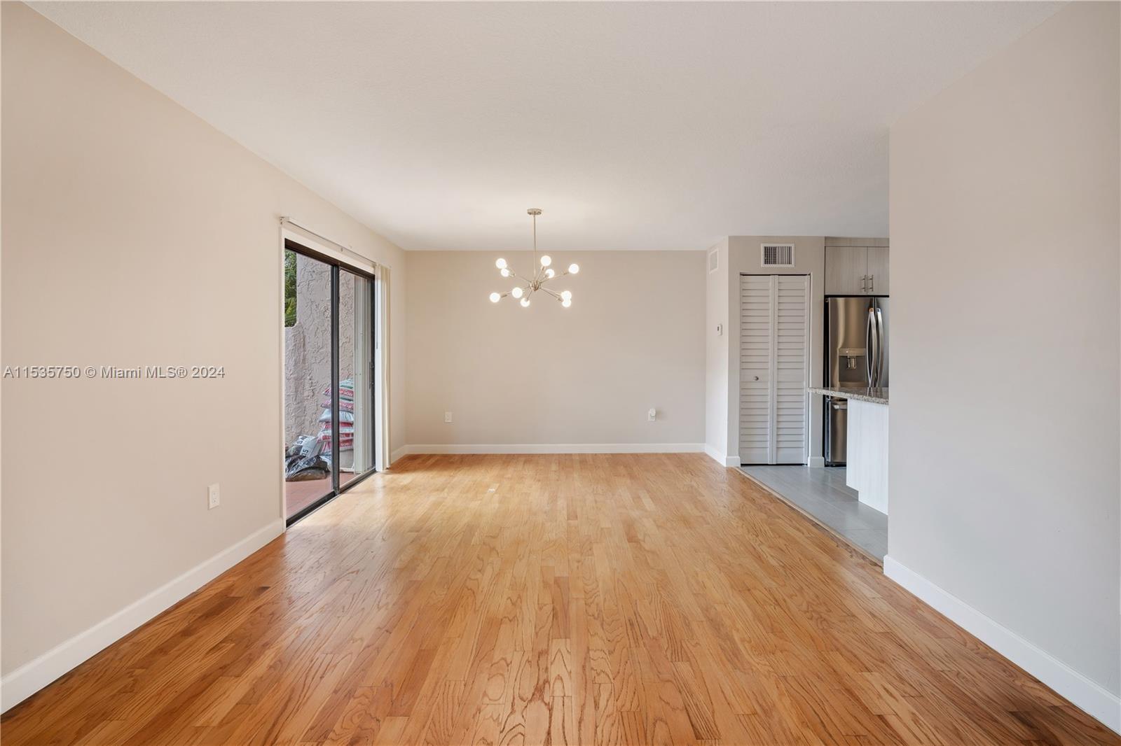 13225 Southwest 95th Avenue, Unit 13225 Miami, FL 33176 - Photo 11 of 36 wooden floor in an empty room with a window