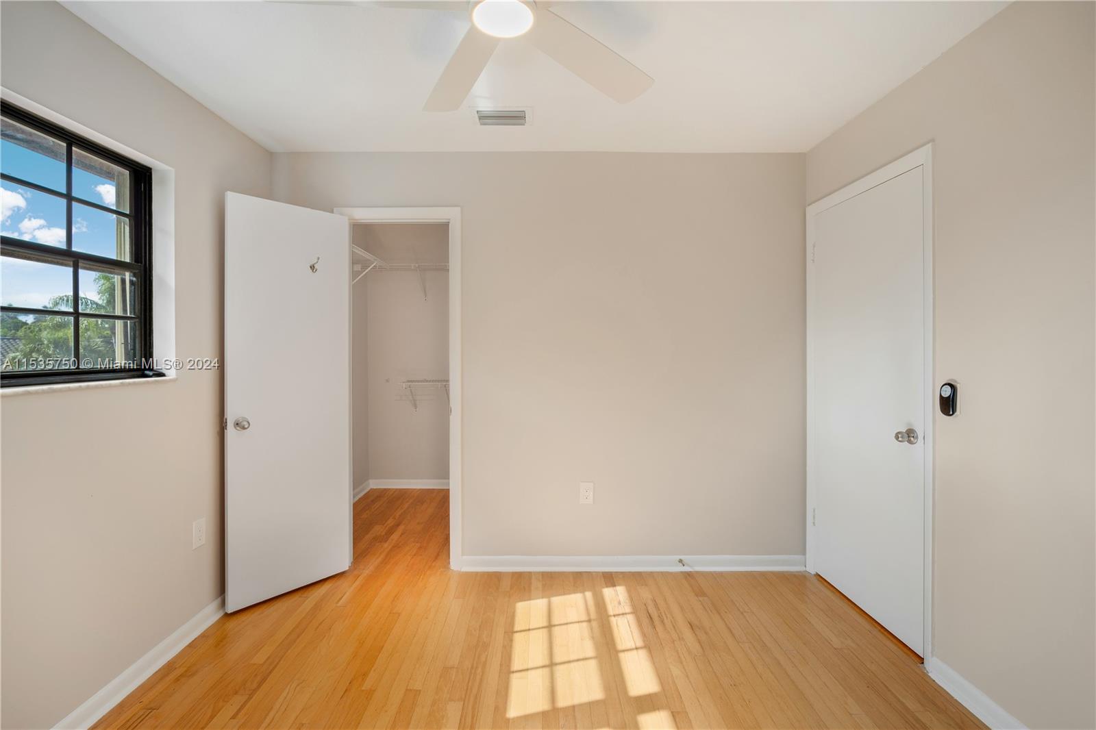 13225 Southwest 95th Avenue, Unit 13225 Miami, FL 33176 - Photo 19 of 36 an empty room with wooden floor and windows