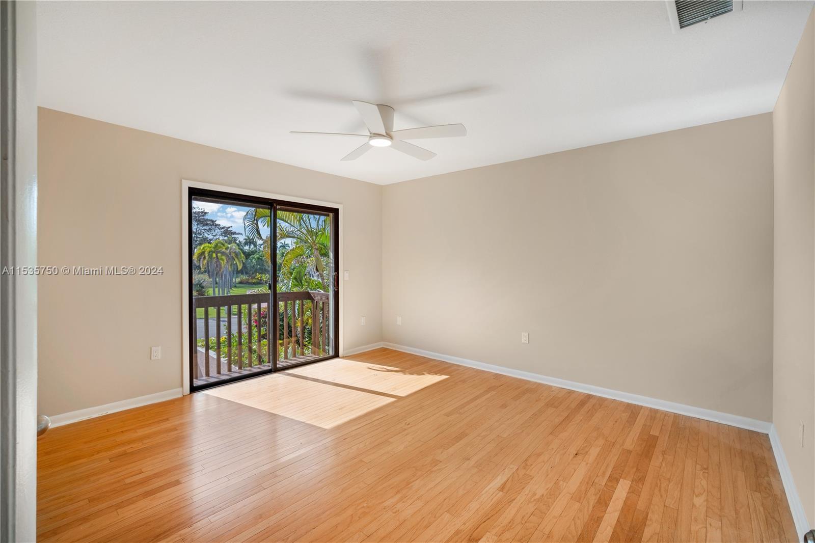 13225 Southwest 95th Avenue, Unit 13225 Miami, FL 33176 - Photo 21 of 36 a view of an empty room with wooden floor and a window