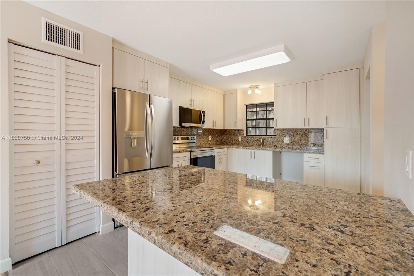 13225 Southwest 95th Avenue, Unit 13225 Miami, FL 33176 - Photo 3 of 36 a kitchen with stainless steel appliances granite countertop a sink refrigerator and cabinets