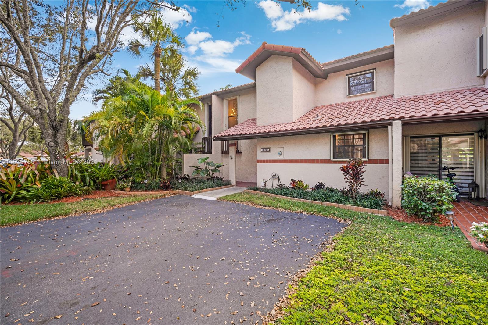 13225 Southwest 95th Avenue, Unit 13225 Miami, FL 33176 - Photo 31 of 36 a front view of a house with a yard and a garage