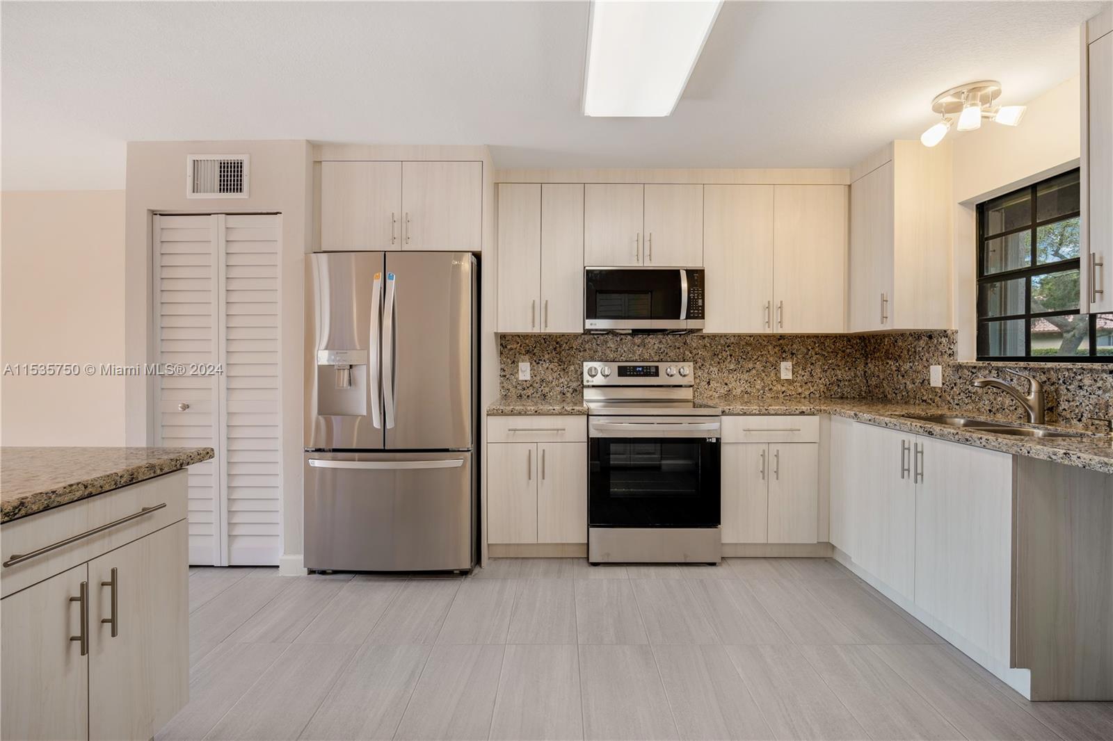 13225 Southwest 95th Avenue, Unit 13225 Miami, FL 33176 - Photo 4 of 36 a kitchen with stainless steel appliances granite countertop a refrigerator stove a sink and dishwasher