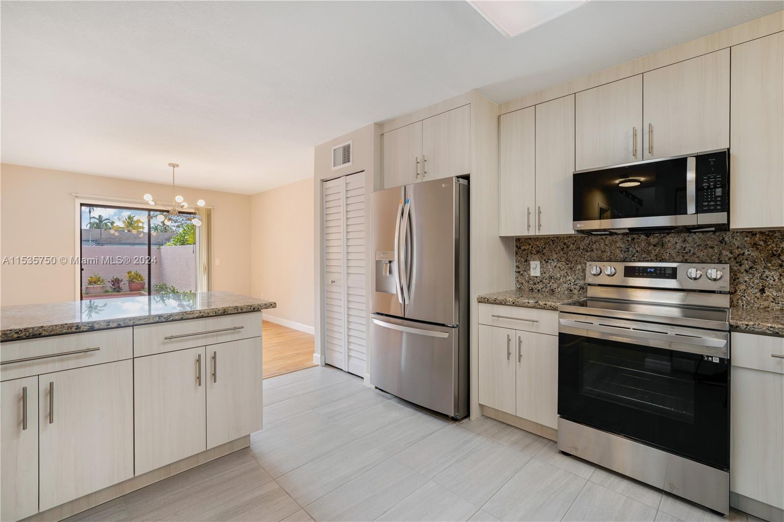 13225 Southwest 95th Avenue, Unit 13225 Miami, FL 33176 - Photo 5 of 36 a kitchen with stainless steel appliances granite countertop a refrigerator stove and sink