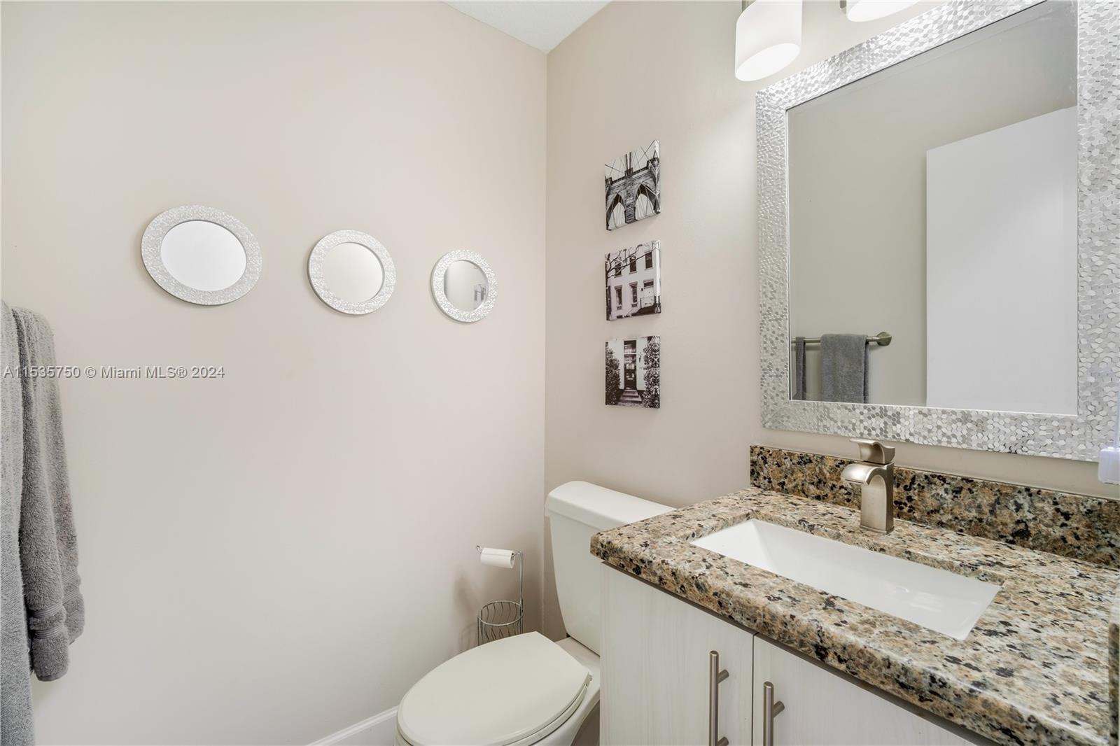 13225 Southwest 95th Avenue, Unit 13225 Miami, FL 33176 - Photo 6 of 36 a bathroom with a granite countertop sink mirror vanity and toilet