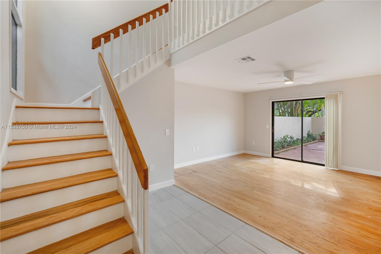 13225 Southwest 95th Avenue, Unit 13225 Miami, FL 33176 - Photo 7 of 36 a view of an empty room with wooden floor and stairs