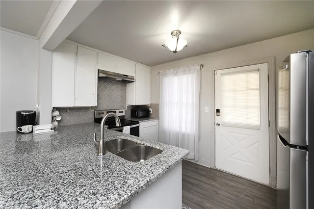 a kitchen with a refrigerator sink and cabinets