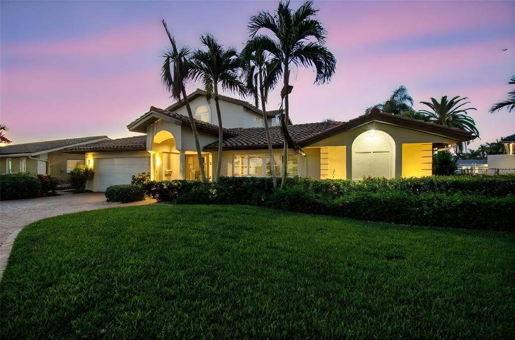 a front view of a house with a garden and yard