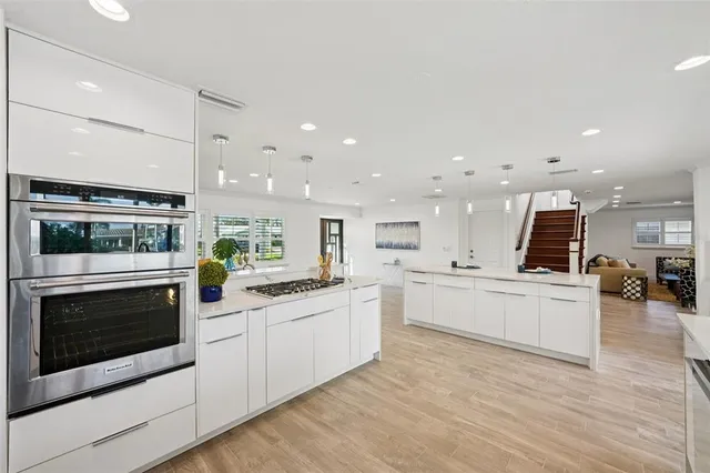 a large white kitchen with a large window