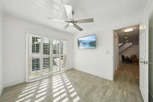 a view of a hallway with wooden floor and a livingroom