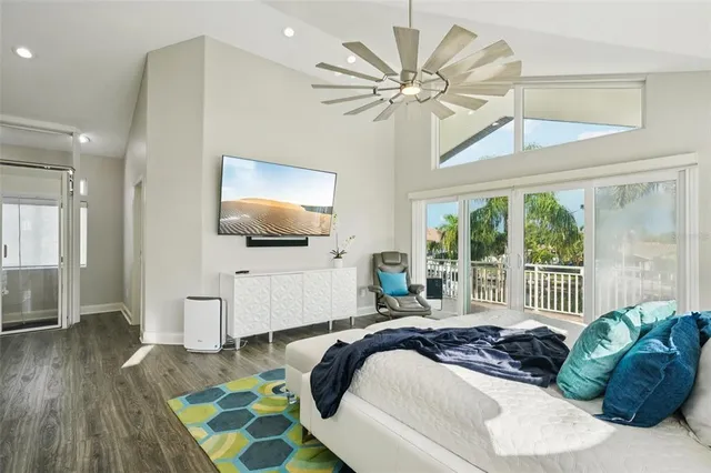 a bedroom with a bed a chandelier and a large window