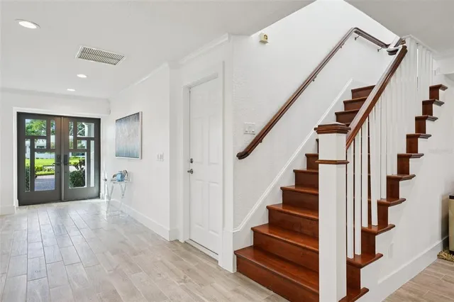 a view of staircase with wooden floor and white walls