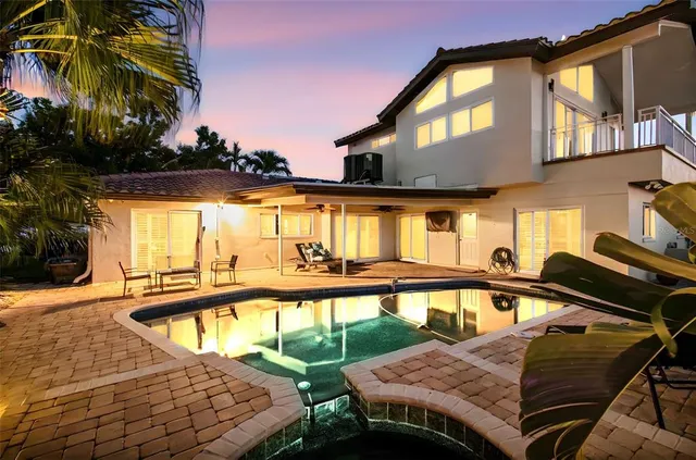a view of a patio with couches table and chairs with potted plants and a barbeque grill