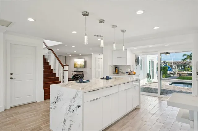 a large white kitchen with a large counter top and stainless steel appliances