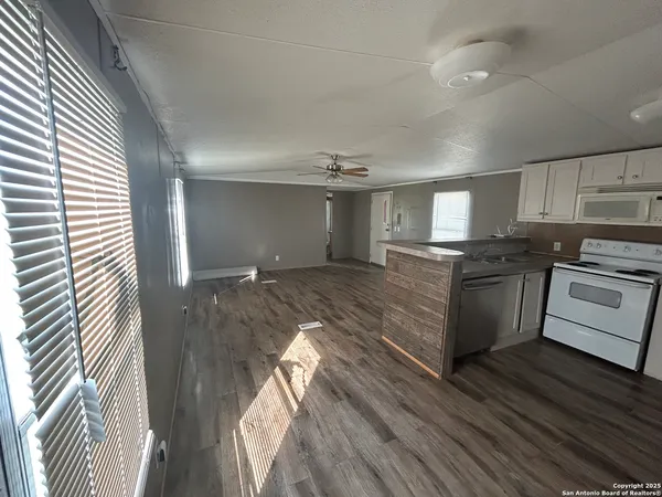 a kitchen with granite countertop a sink cabinets stainless steel appliances and a window