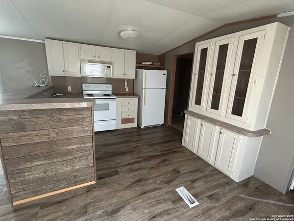 a kitchen with granite countertop white cabinets and stainless steel appliances