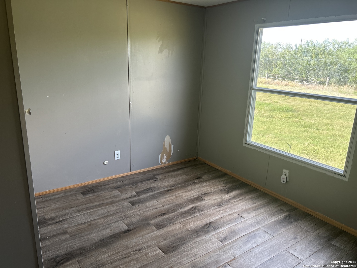 1242 Cologne Road Victoria, TX 77905 - Photo 10 of 29 a view of an empty room with wooden floor and a window