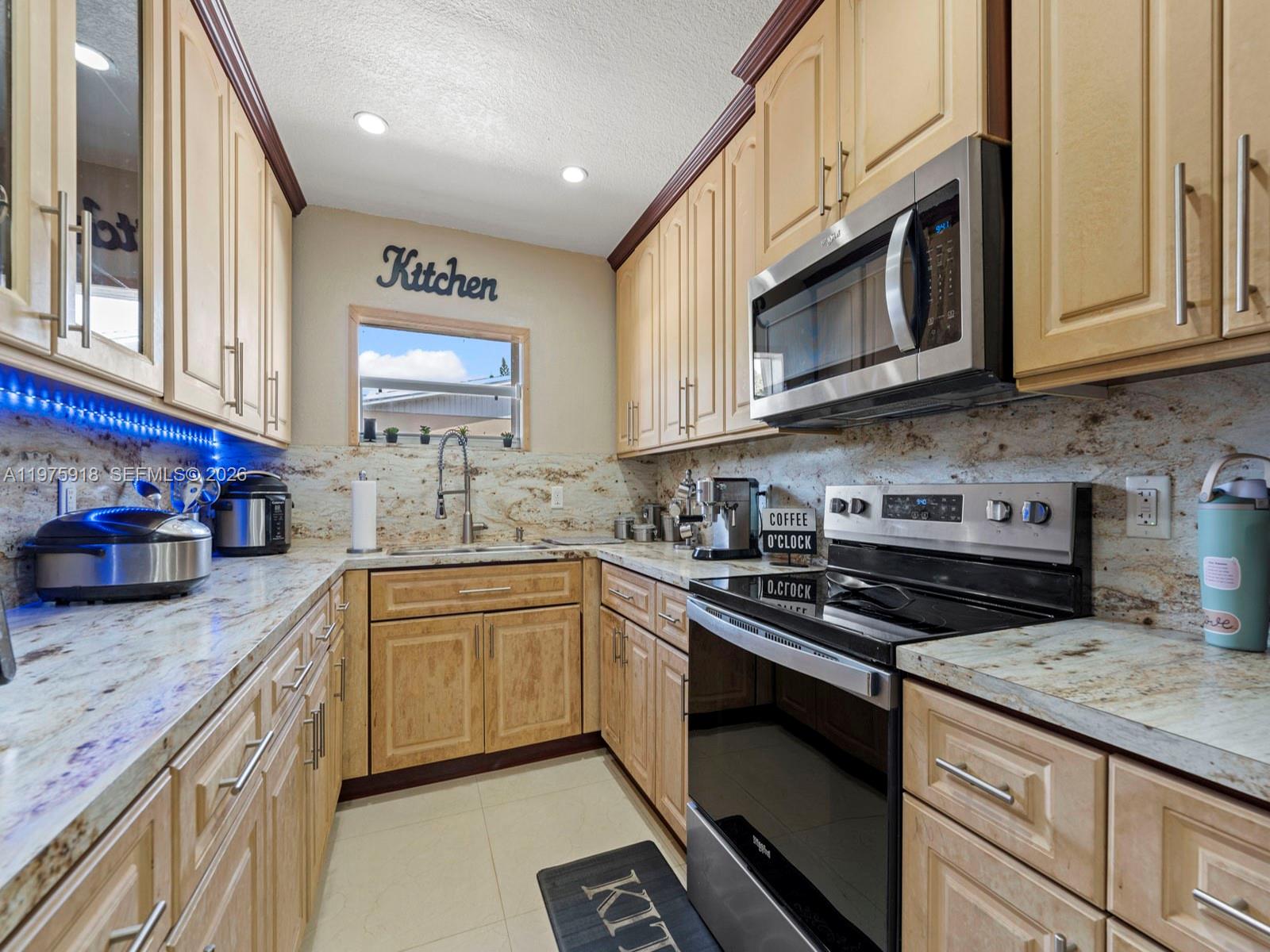 30236 Southwest 148th Place Homestead, FL 33033 - Photo 16 of 69 a kitchen with stainless steel appliances granite countertop a stove a sink and a microwave