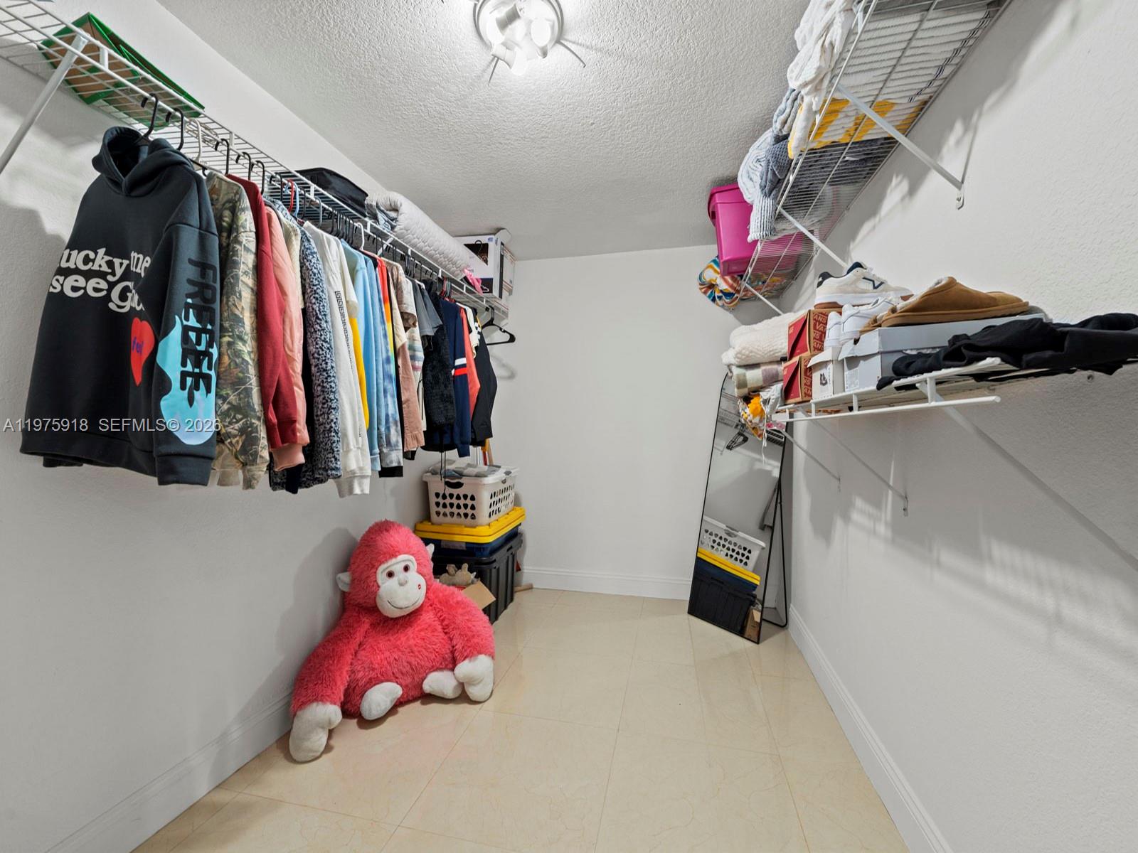 30236 Southwest 148th Place Homestead, FL 33033 - Photo 49 of 69 a view of walk in closet with clothes and shoes