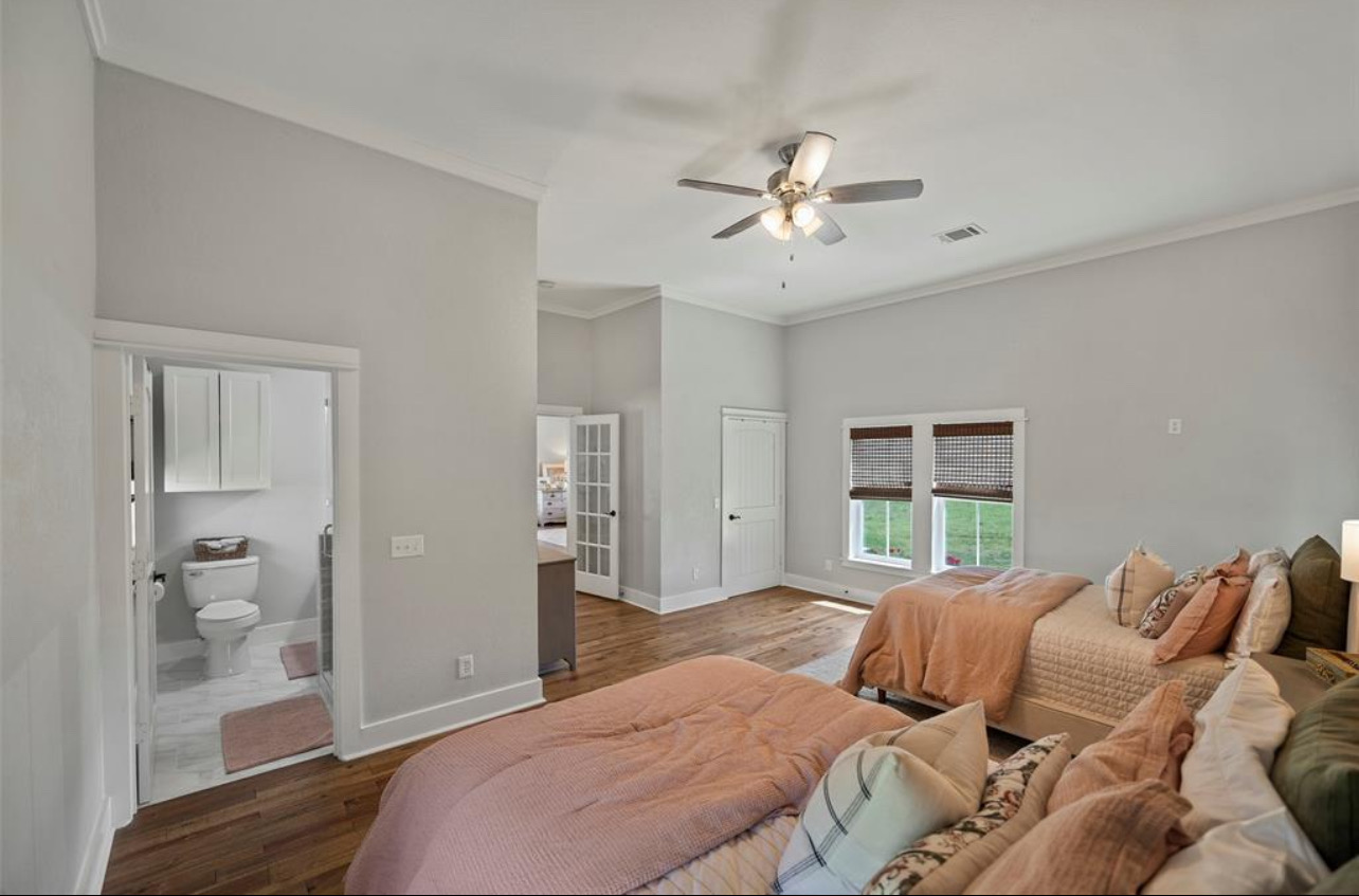 539 Elm Street New Ulm, TX 78950 - Photo 13 of 21 a bedroom with a large bed and a chandelier