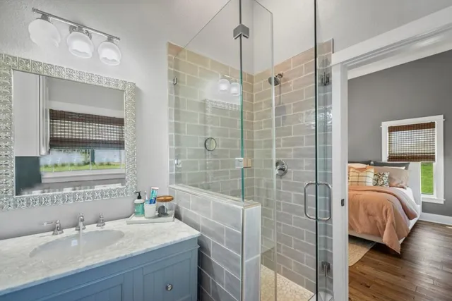 a en suite bathroom with a shower sink and mirror