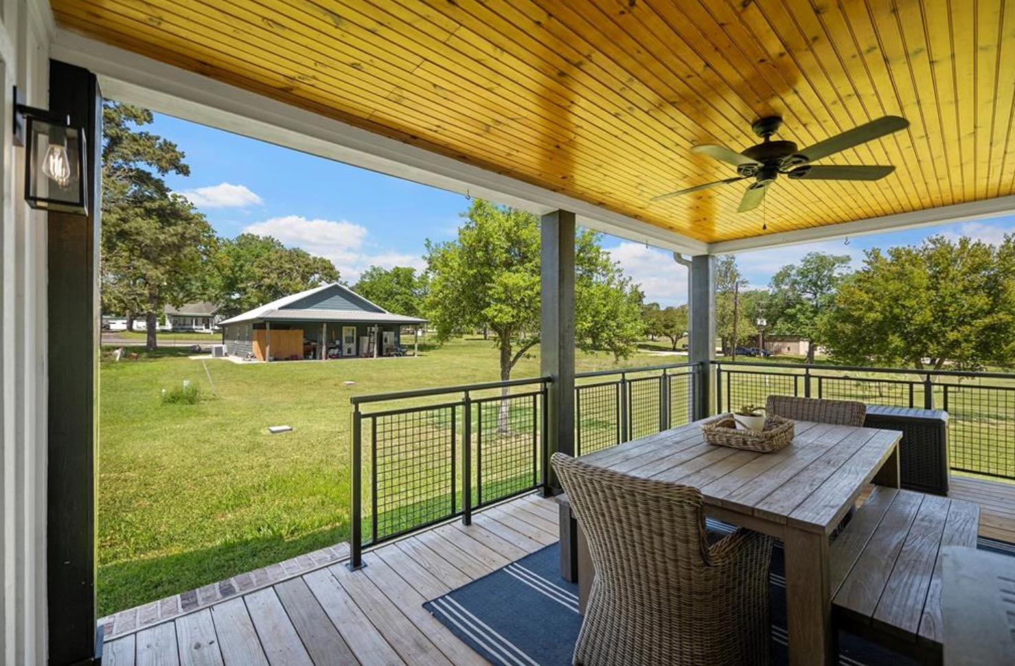 539 Elm Street New Ulm, TX 78950 - Photo 19 of 21 a view of a patio with table and chairs a barbeque with wooden floor and fence