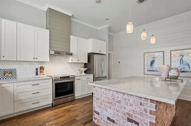 a kitchen with stainless steel appliances granite countertop a sink a stove and cabinets