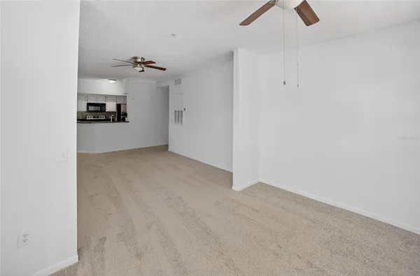 an empty room with kitchen view