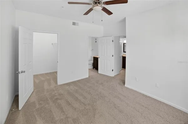a view of a livingroom with a ceiling fan & entryway