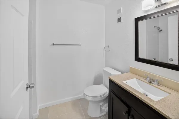 a bathroom with a granite countertop sink a toilet and a mirror