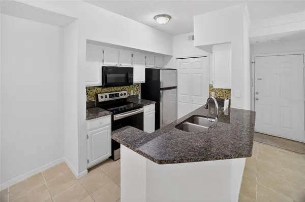 a kitchen with kitchen island a sink stainless steel appliances and a counter top space