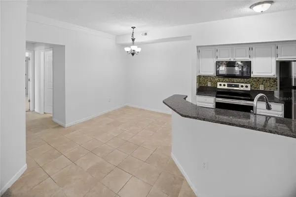 a kitchen with stainless steel appliances granite countertop a sink a stove top oven a counter space and cabinets