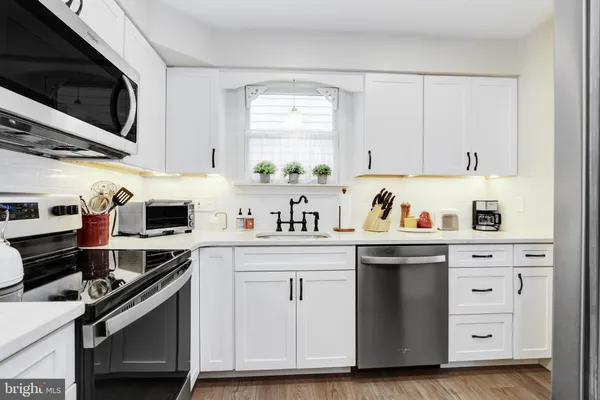 a kitchen with stainless steel appliances a stove a sink and cabinets