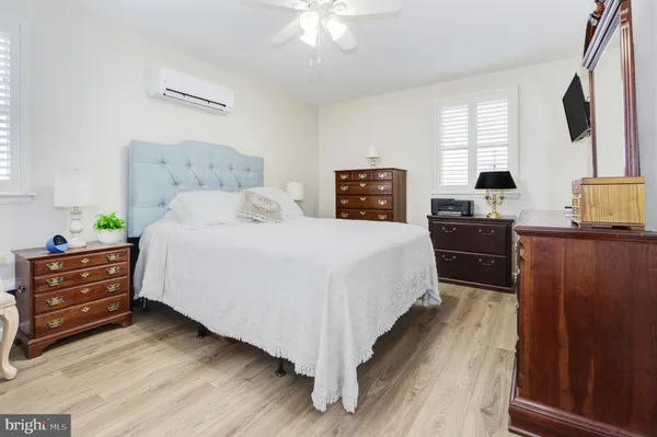 a bedroom with a bed and a flat tv screen on dresser