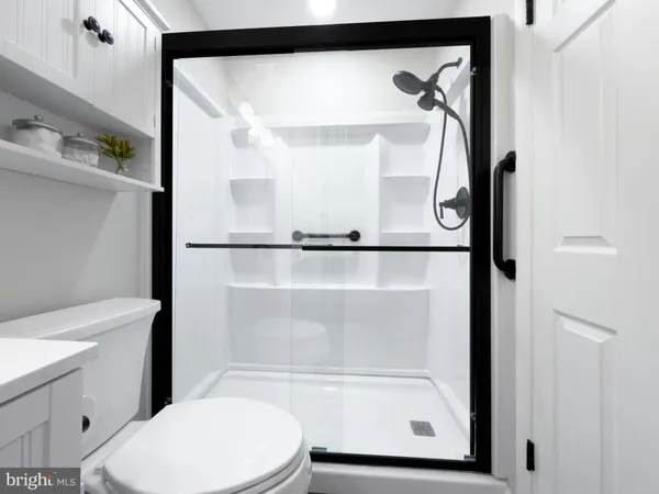 a bathroom with a glass shower door and a toilet