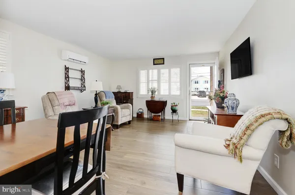 a living room with furniture a flat screen tv and floor to ceiling window