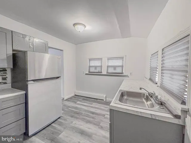 a kitchen with a sink a refrigerator and cabinets