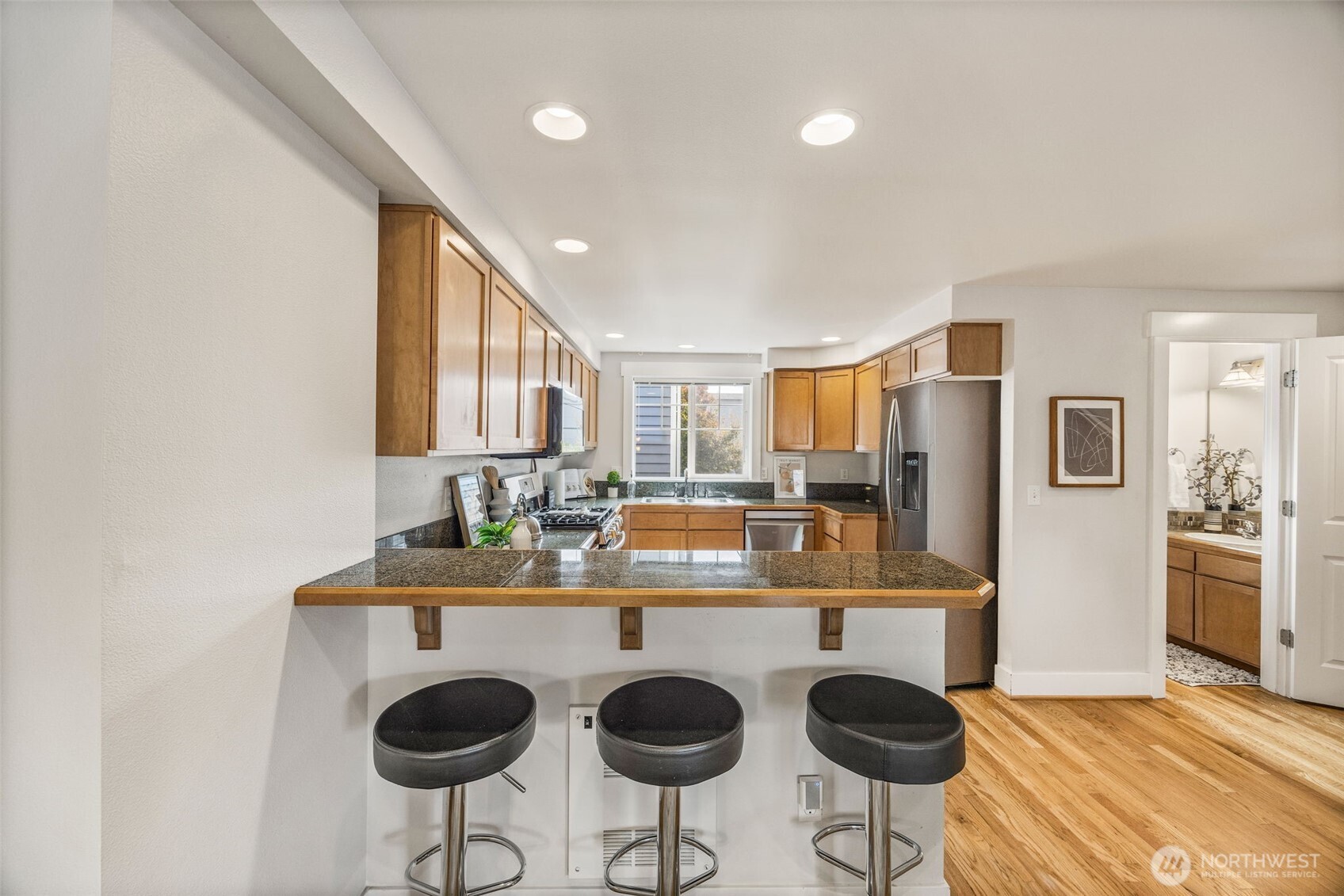 910 Northwest 85th Street, Unit B Seattle, WA 98117 - Photo 11 of 21 a kitchen with stainless steel appliances granite countertop a sink and a refrigerator