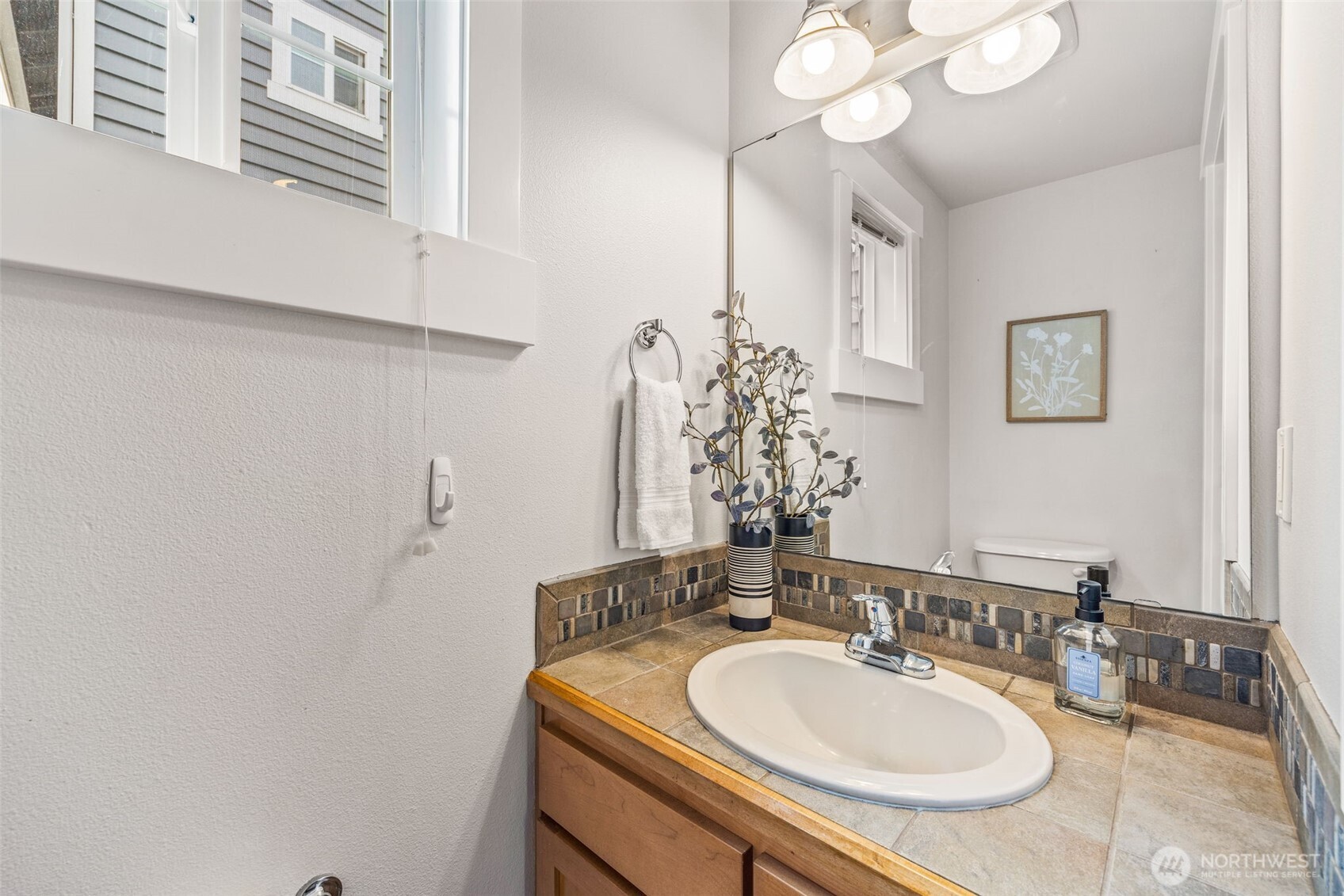 910 Northwest 85th Street, Unit B Seattle, WA 98117 - Photo 13 of 21 a bathroom with a sink and a mirror