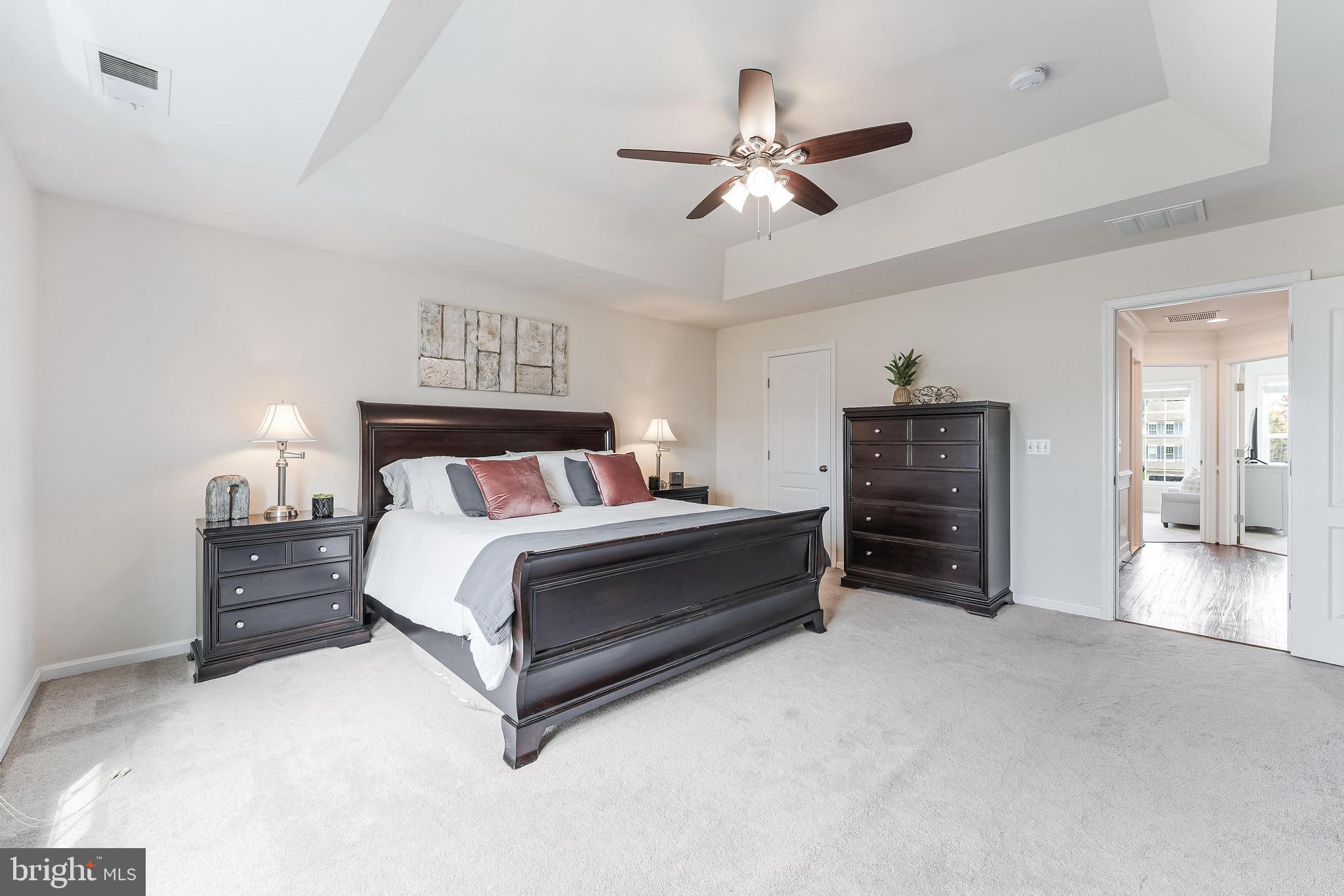 42467 Patrick Wayne Square Ashburn, VA 20148 - Photo 20 of 60 a spacious bedroom with a bed and a chandelier