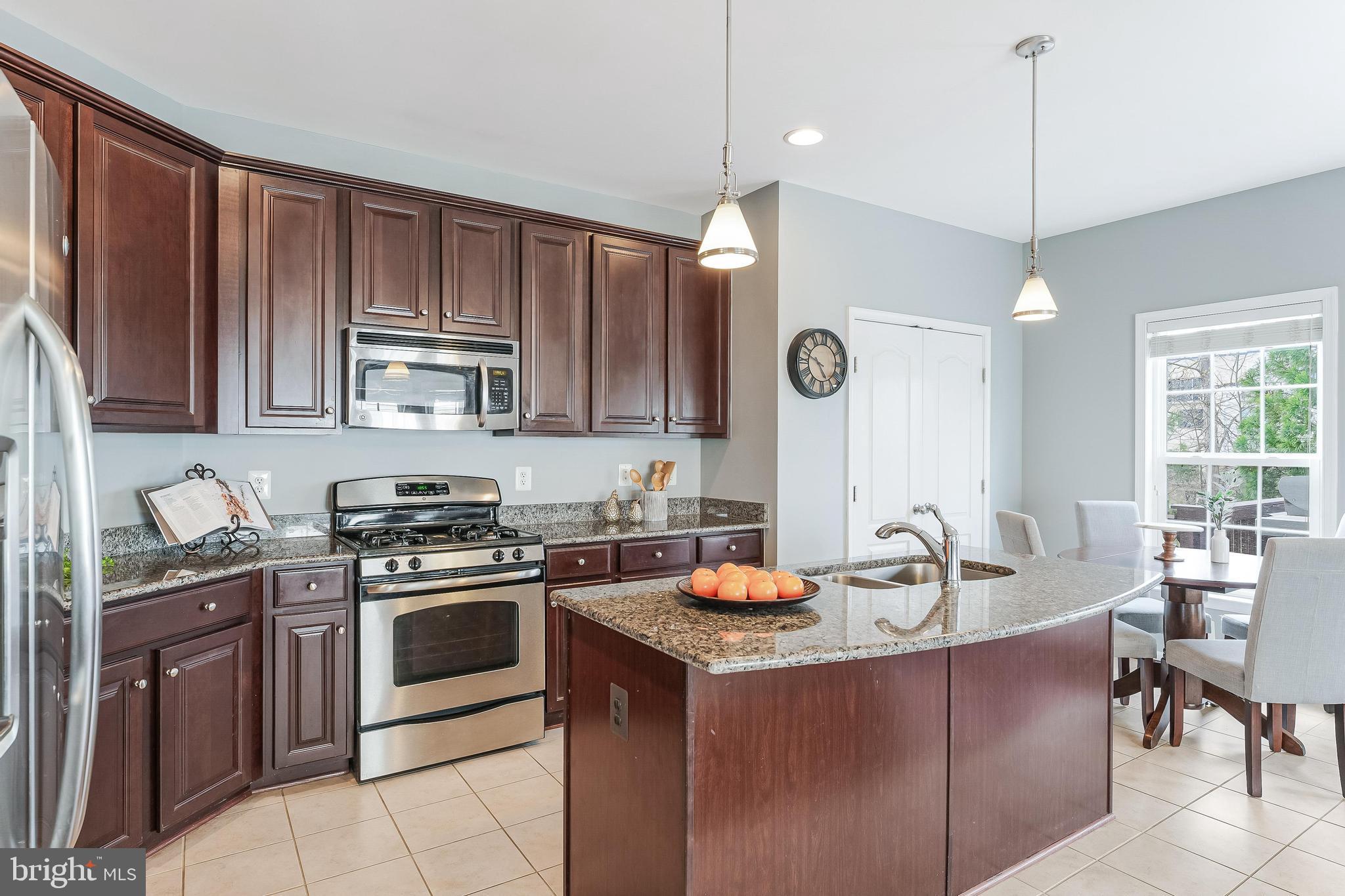 42467 Patrick Wayne Square Ashburn, VA 20148 - Photo 4 of 60 a kitchen with a stove a sink and a microwave