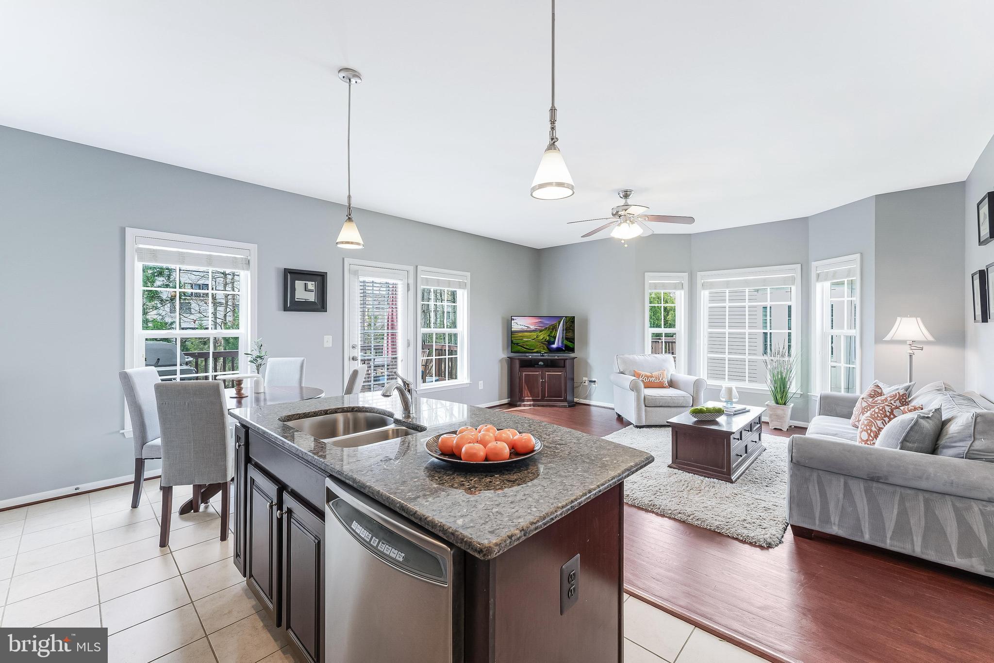 42467 Patrick Wayne Square Ashburn, VA 20148 - Photo 8 of 60 a living room with furniture a dining table and a floor to ceiling window