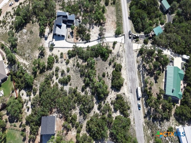 an aerial view of residential house with outdoor space and trees all around