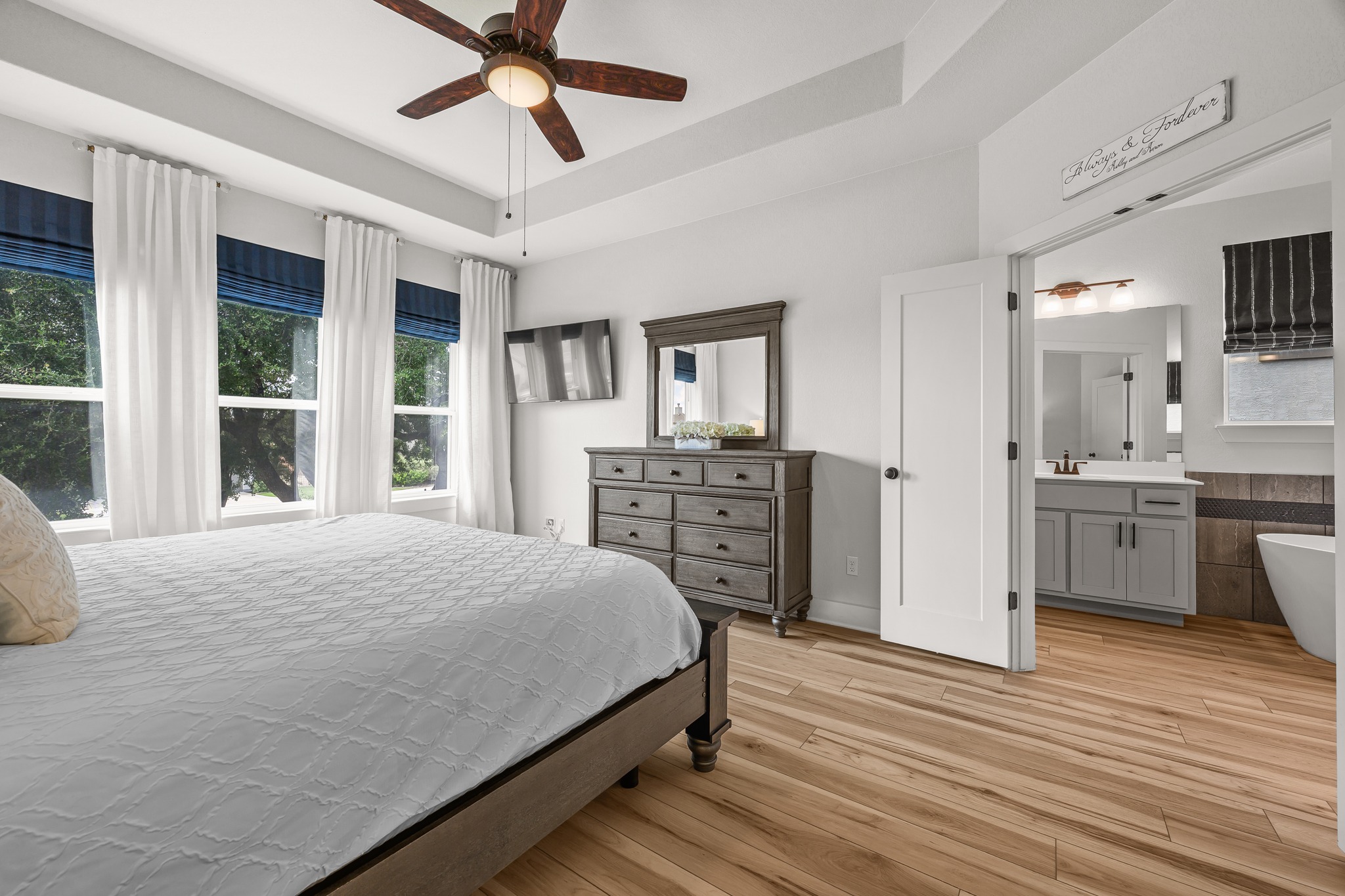 68 Rancho Trail Georgetown, TX 78628 - Photo 15 of 39 A tranquil bedroom retreat features tray ceilings and ample natural light, connecting to a private primary bathroom.
