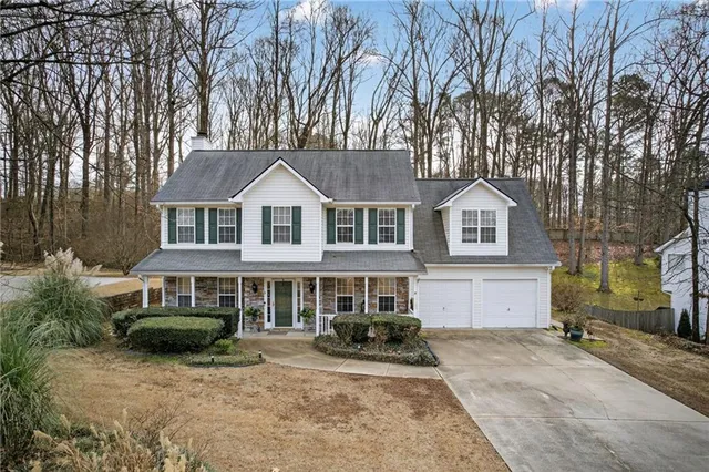 a front view of a house with yard porch and tree