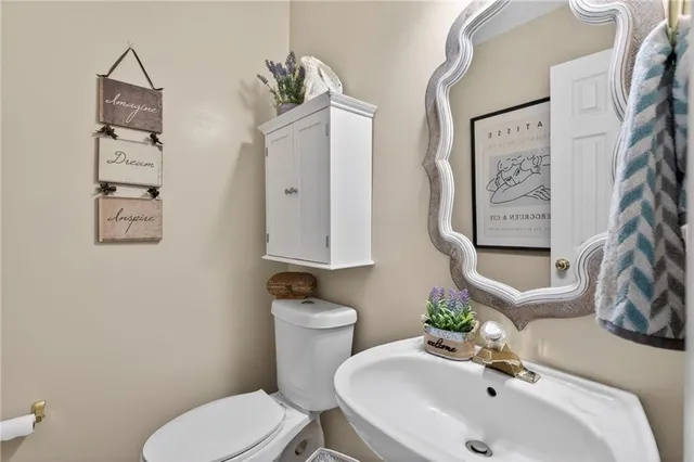 a bathroom with a toilet sink and mirror